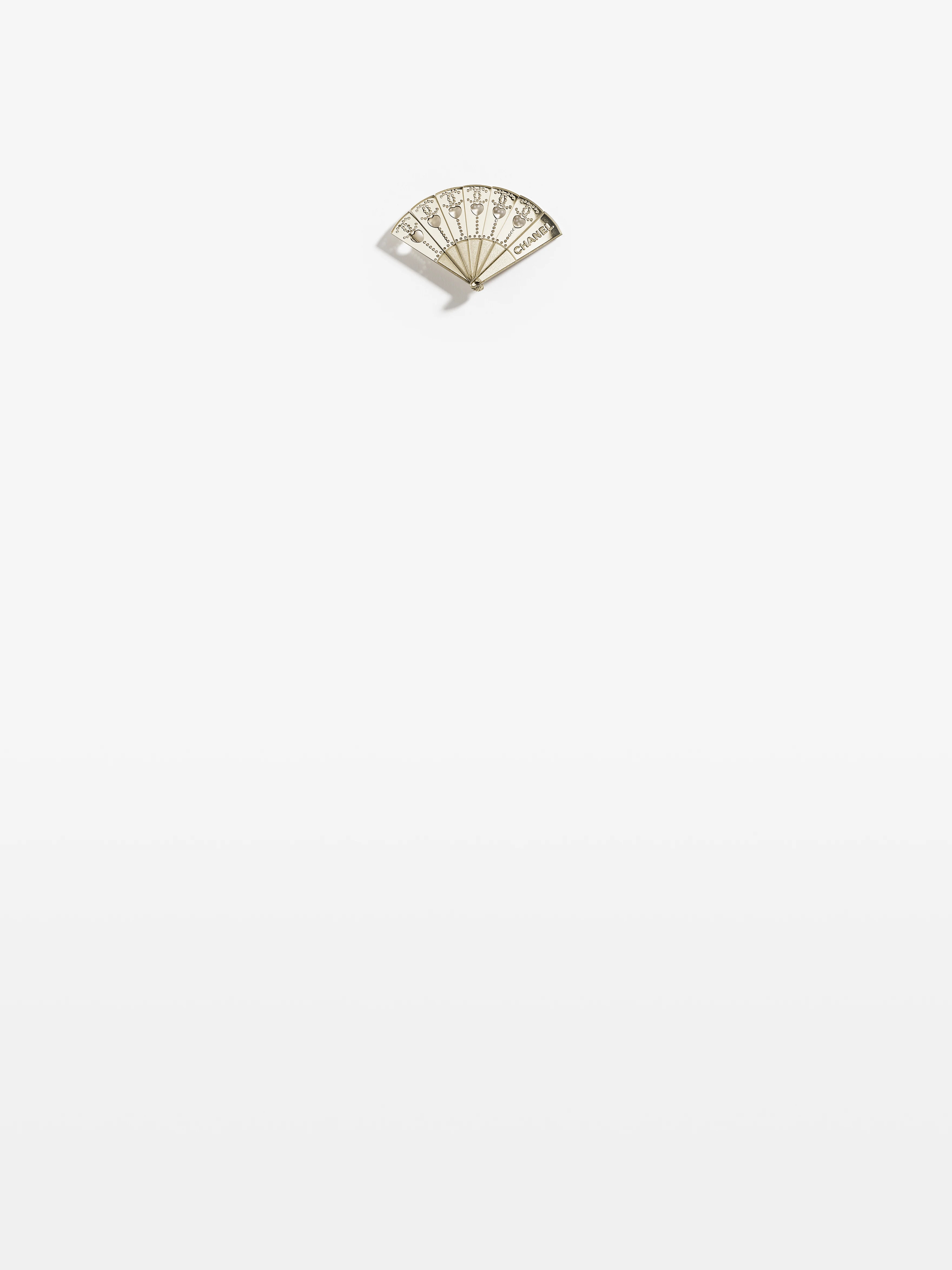 chanel brooch in metal and gold.jpeg